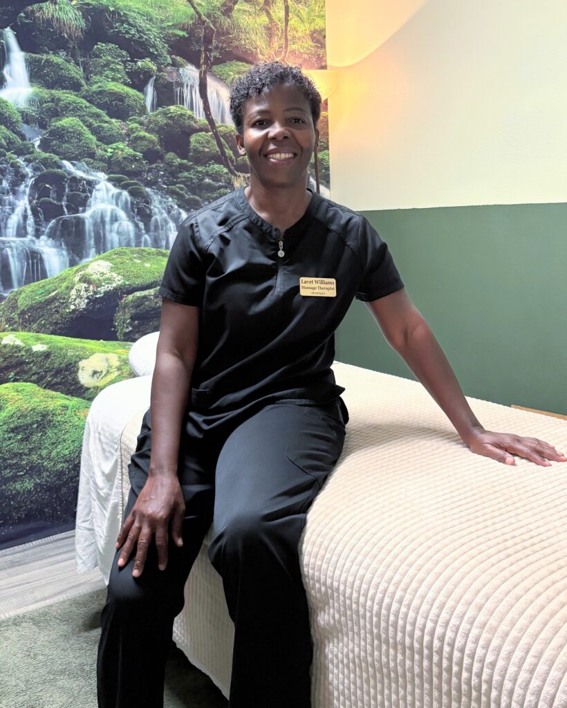 Lavet Williams sitting on a massage table inside Ultimate Massage Studio in Altamonte Springs, Florida.
